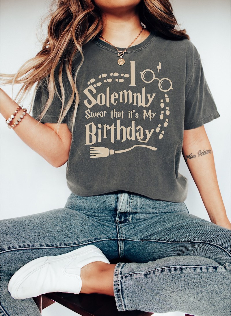Harry Potter-inspired birthday T-shirt featuring the phrase "I Solemnly Swear That It's My Birthday" with glasses, a wand, and Marauder's Map footprints.