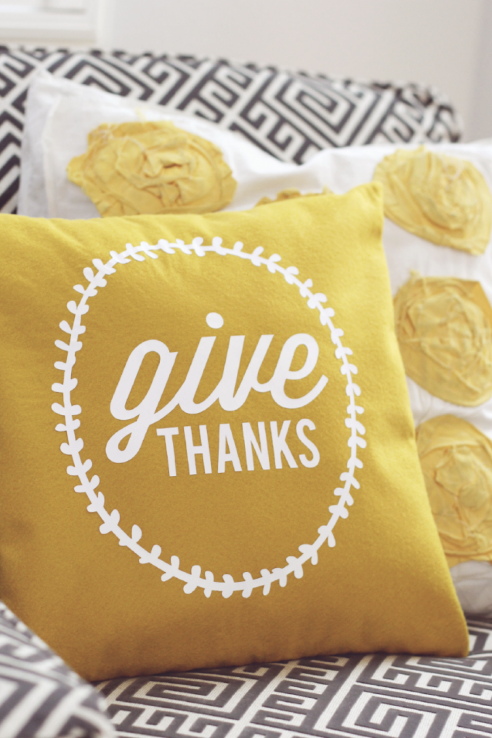 DIY Thanksgiving decor featuring a yellow Give Thanks throw pillow on a cozy chair with fall accents.