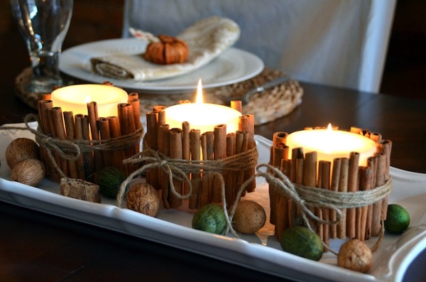 DIY cinnamon stick candle holders tied with twine and displayed on a Thanksgiving table centerpiece.