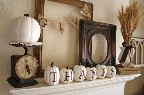 DIY Thanksgiving mantel decorated with white pumpkins, a Give Thanks banner, vintage accents, and fall décor.