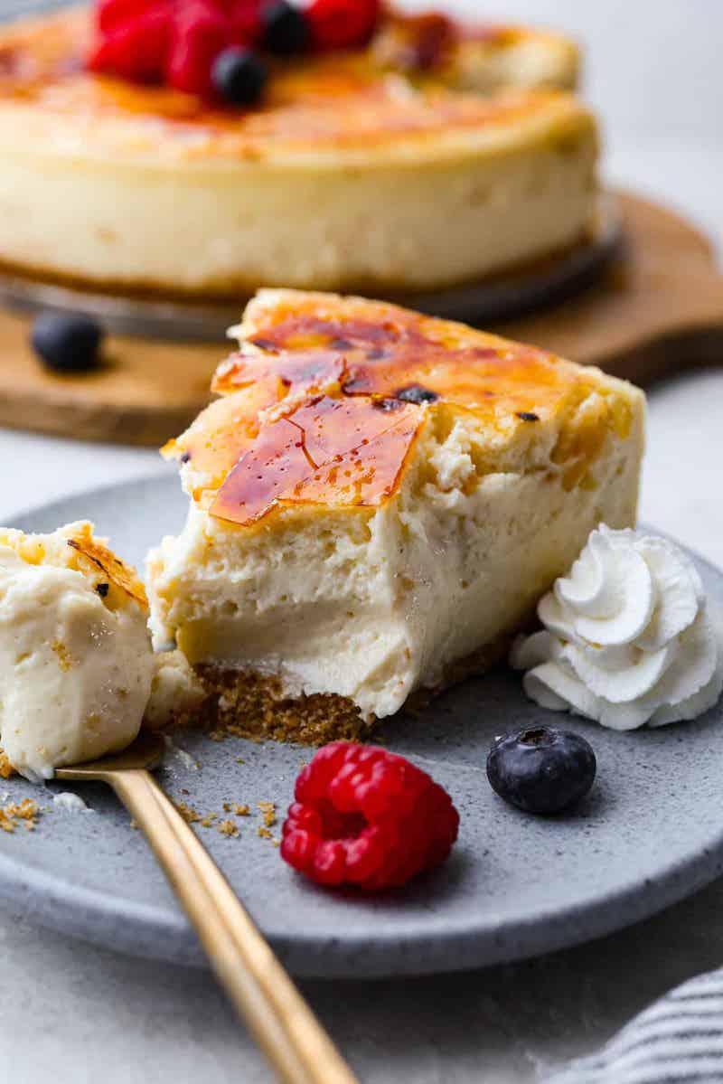A rich, creamy cheesecake is topped with a layer of sugar torched to form a creme brulee topping.