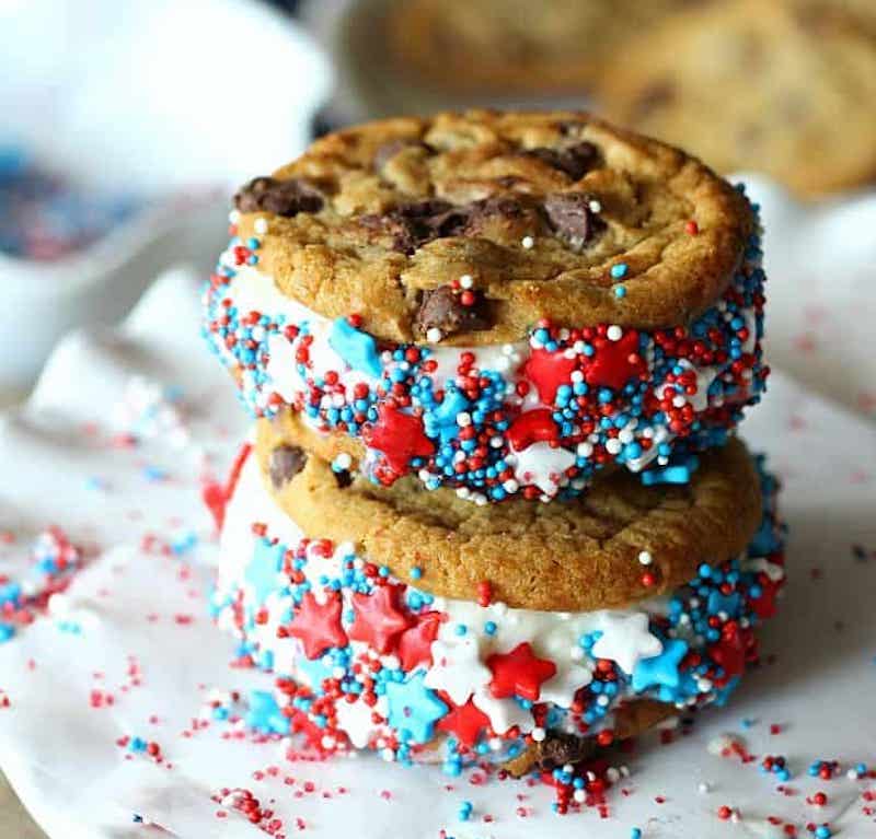 Chocolate chip cookie ice cream sandwiches dipped in red, white, and blue sprinkles for an easy patriotic Fourth of July dessert.