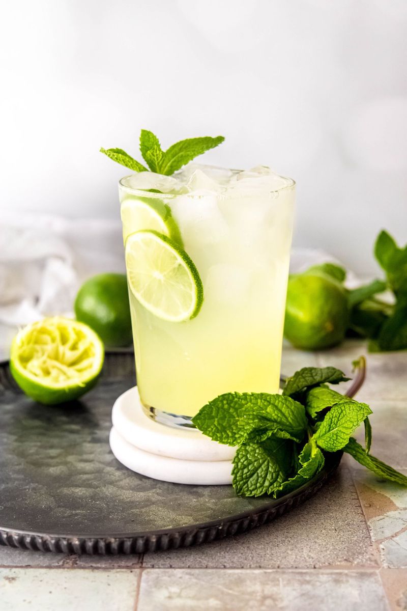 A Starbucks copycat Cool Lime Refresher served over ice with fresh lime slices and mint.