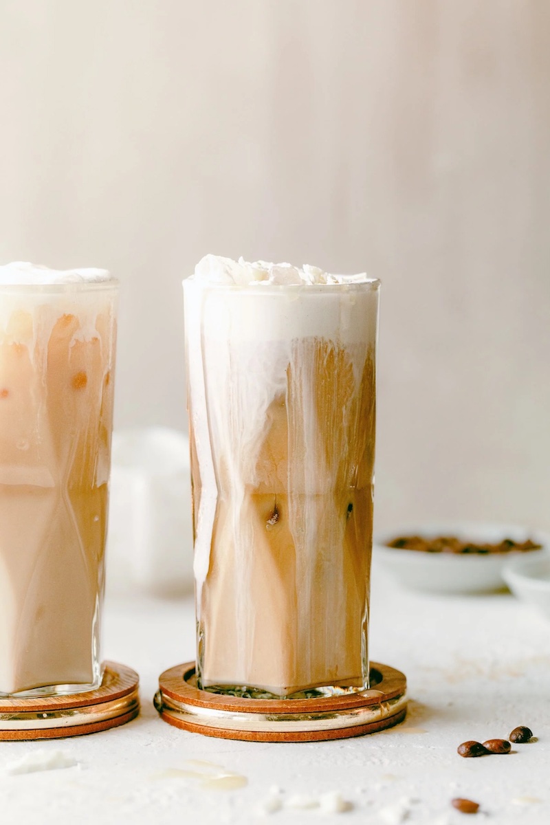 A creamy Iced White Chocolate Mocha topped with whipped cream in a tall glass.