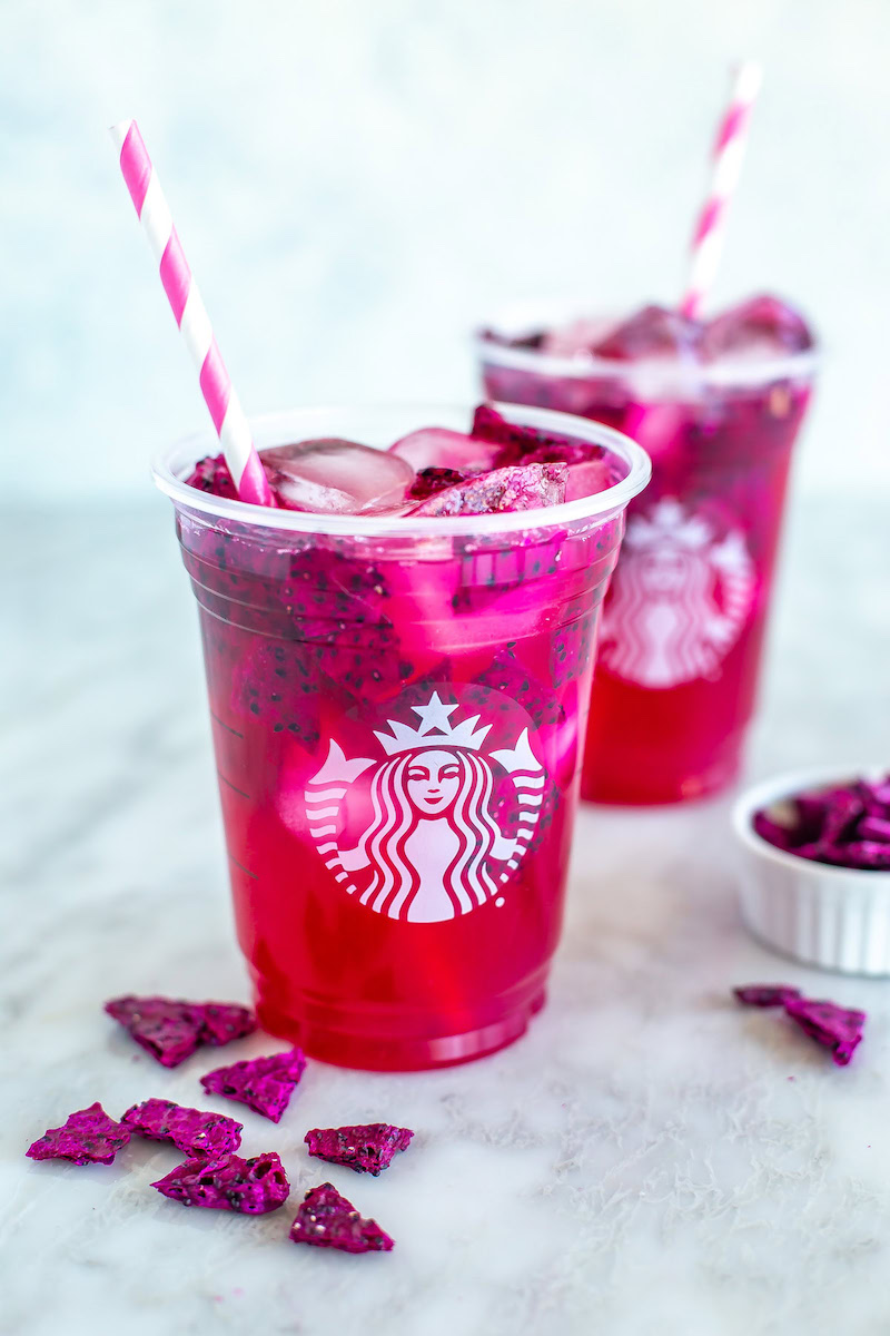 A Starbucks copycat Mango Dragonfruit Refresher served over ice with freeze-dried dragon fruit pieces.