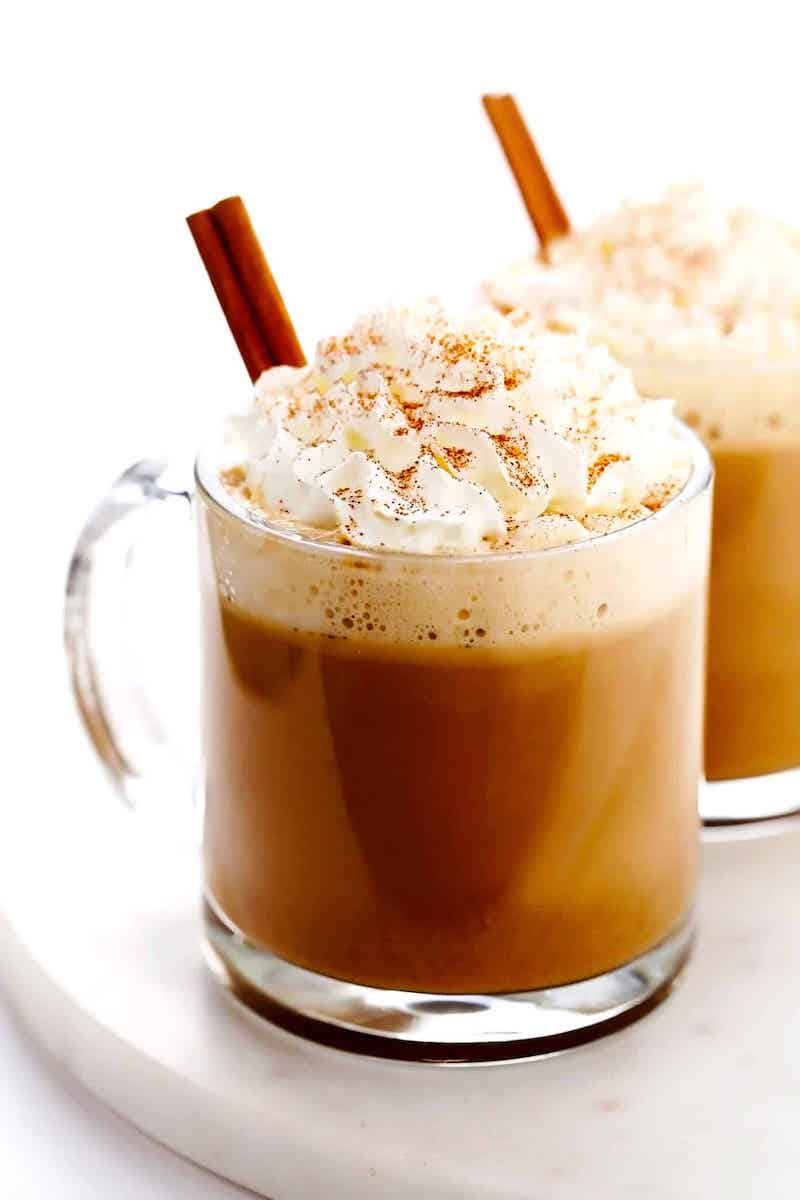 A homemade Pumpkin Spice Latte topped with whipped cream, cinnamon, and a cinnamon stick.