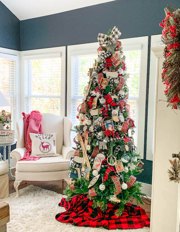 Red plaid Christmas tree with rustic wooden ornaments and buffalo check tree skirt.