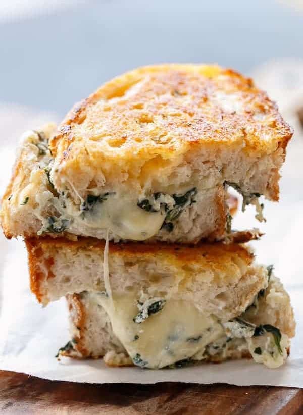 Spinach and ricotta grilled cheese sandwich made with melted mozzarella, Parmesan, creamy ricotta, and spinach on toasted sourdough bread.