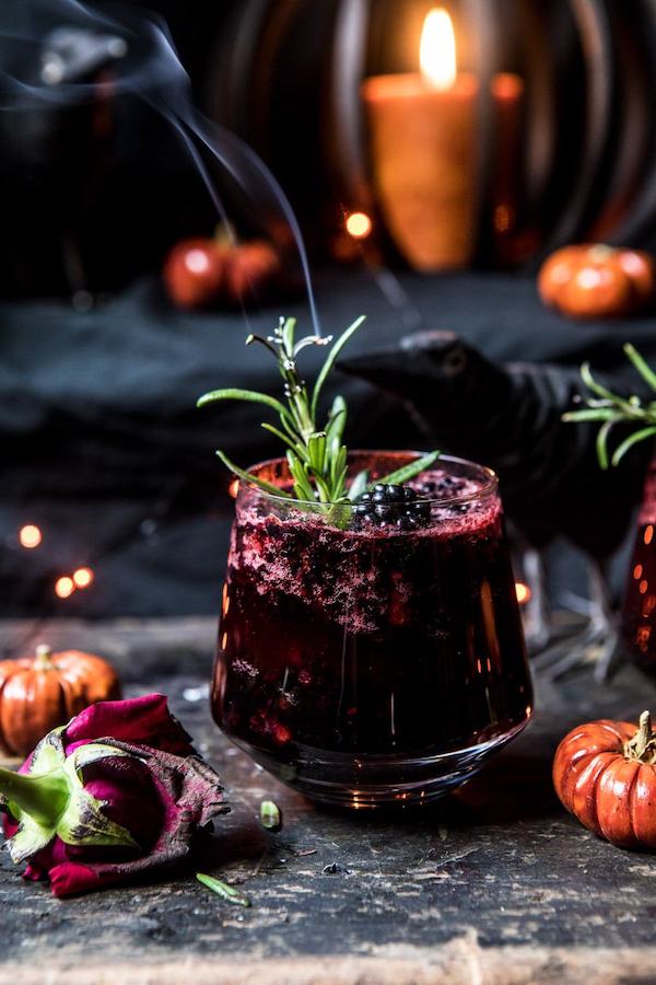 Black widow smash cocktail garnished with rosemary.