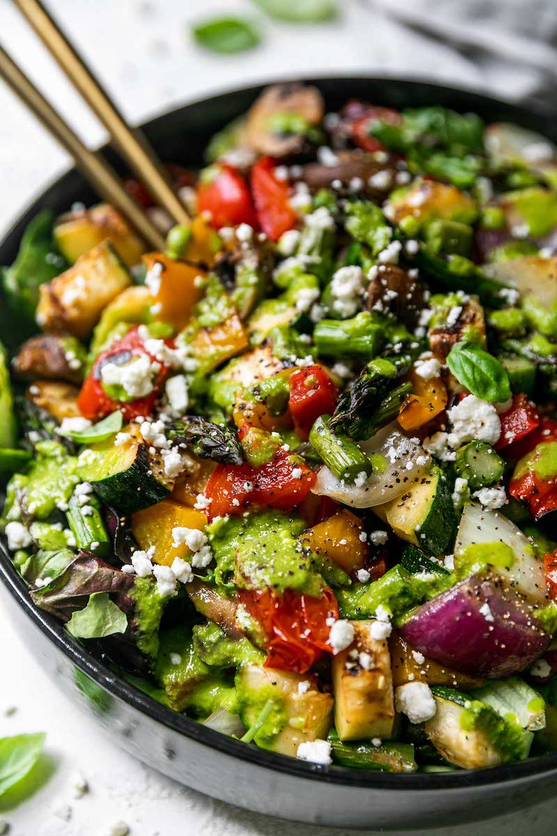 Chopped Grilled Vegetable Salad with asparagus, zucchini, bell peppers, onions, mushrooms, tomatoes, feta cheese, and lemon basil vinaigrette in a black serving bowl.