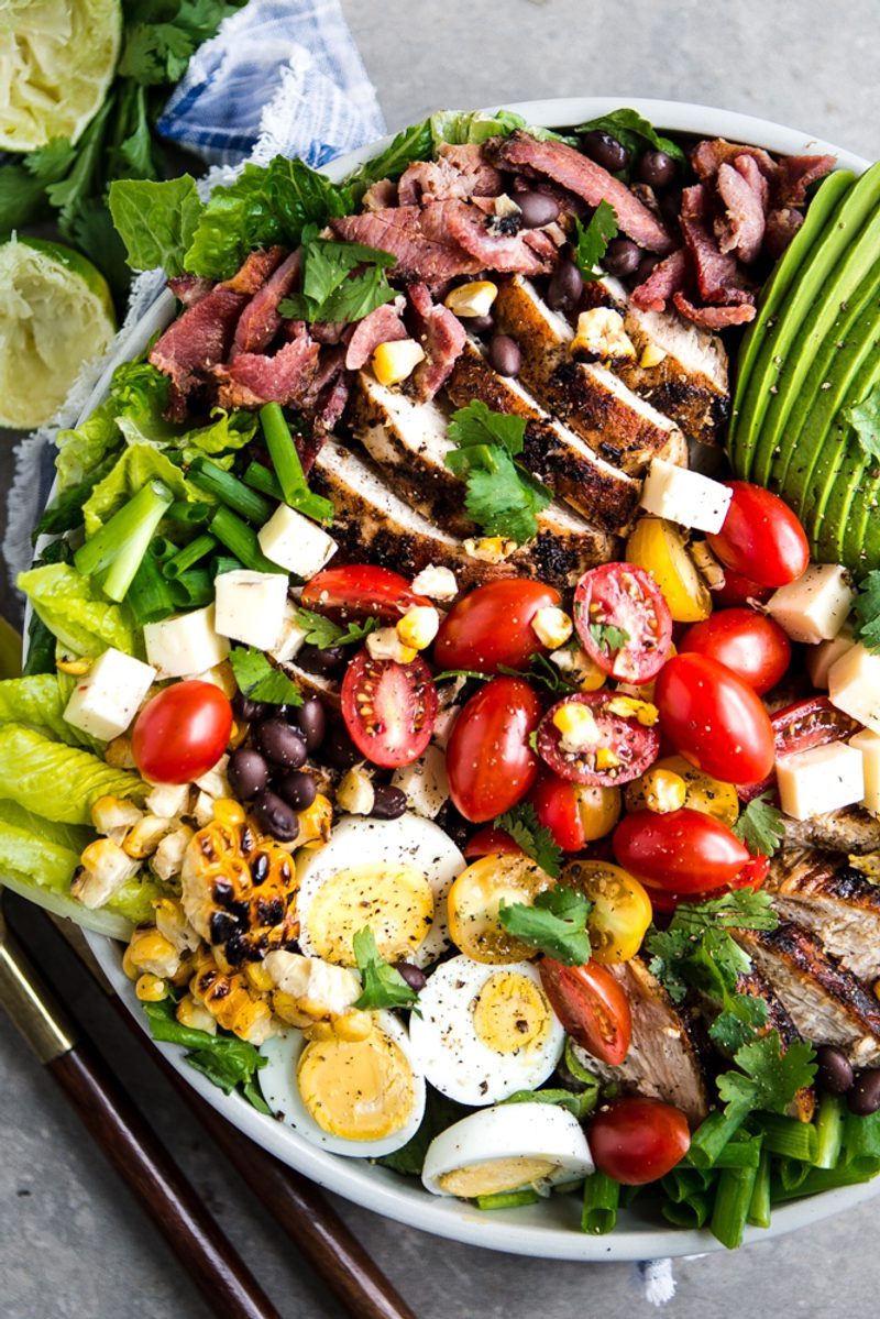 Southwest Cobb salad with grilled chipotle chicken, bacon, avocado, black beans, grilled corn, tomatoes, hard-boiled eggs, pepper Jack cheese, romaine lettuce, and smoky chipotle dressing.