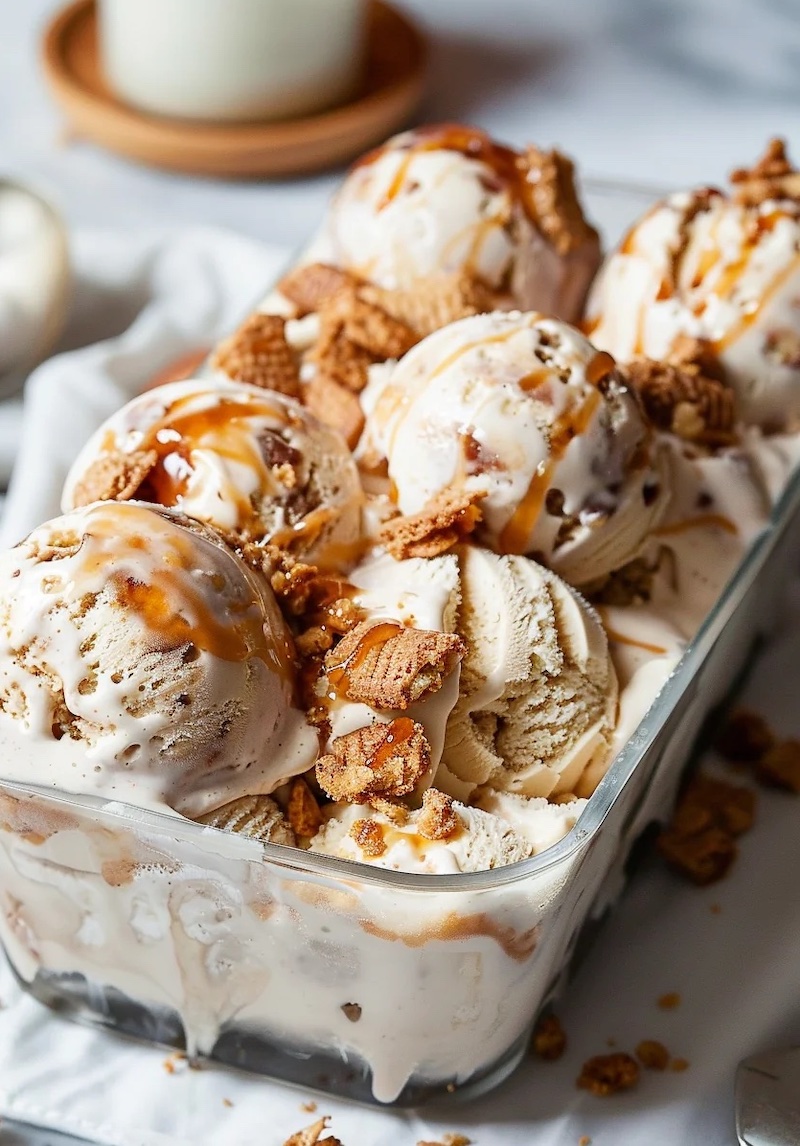 Homemade apple pie ice cream with caramel drizzle, cinnamon apples, and snickerdoodle cookie pieces in a glass dish.