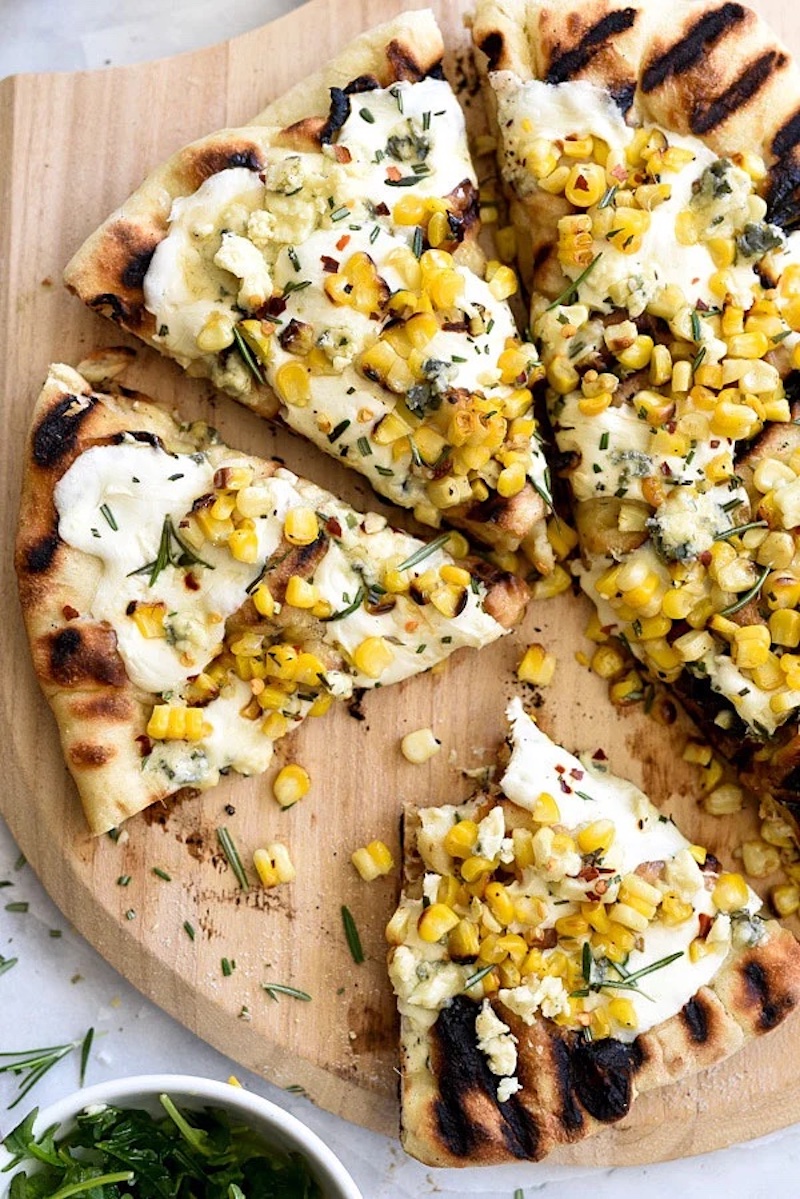Grilled sweet corn pizza topped with mozzarella, Gorgonzola, and fresh rosemary.