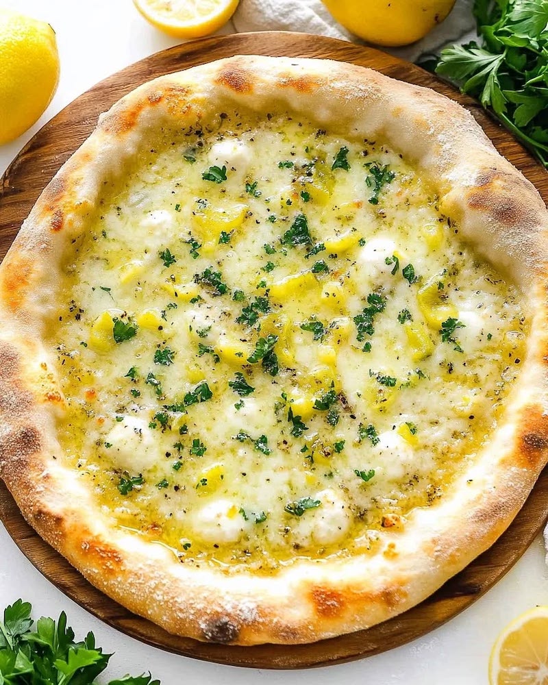 Lemon pizza topped with mozzarella, fresh garlic, herbs, and lemon slices.