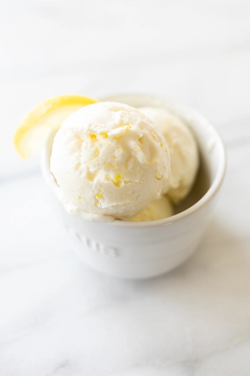 Scoops of creamy no-churn lemon ice cream served in a white ramekin with a smooth, creamy texture and fresh lemon flavor.