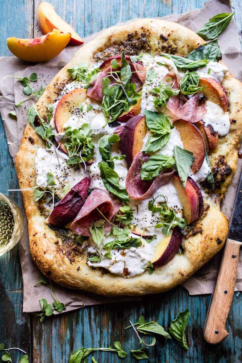 Peach and burrata pizza topped with Italian salami, fresh basil, microgreens, and honey balsamic.