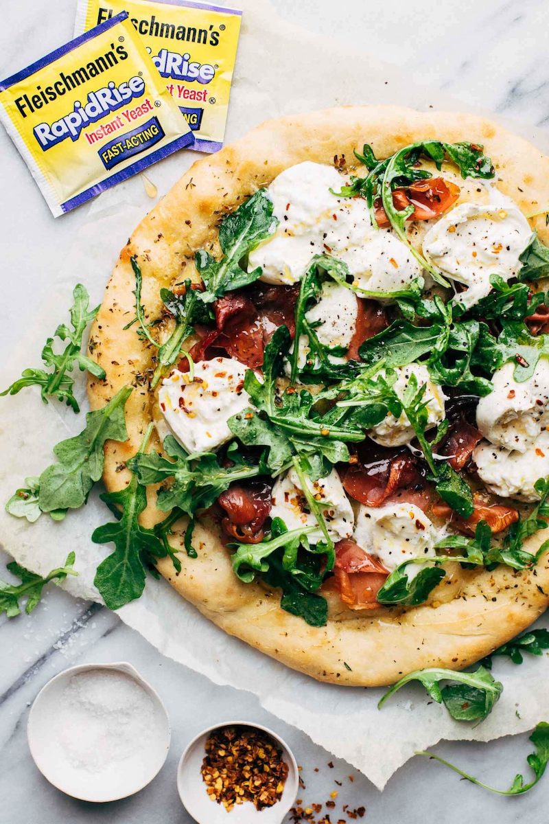Prosciutto pizza topped with burrata, lemony arugula, and a drizzle of honey.