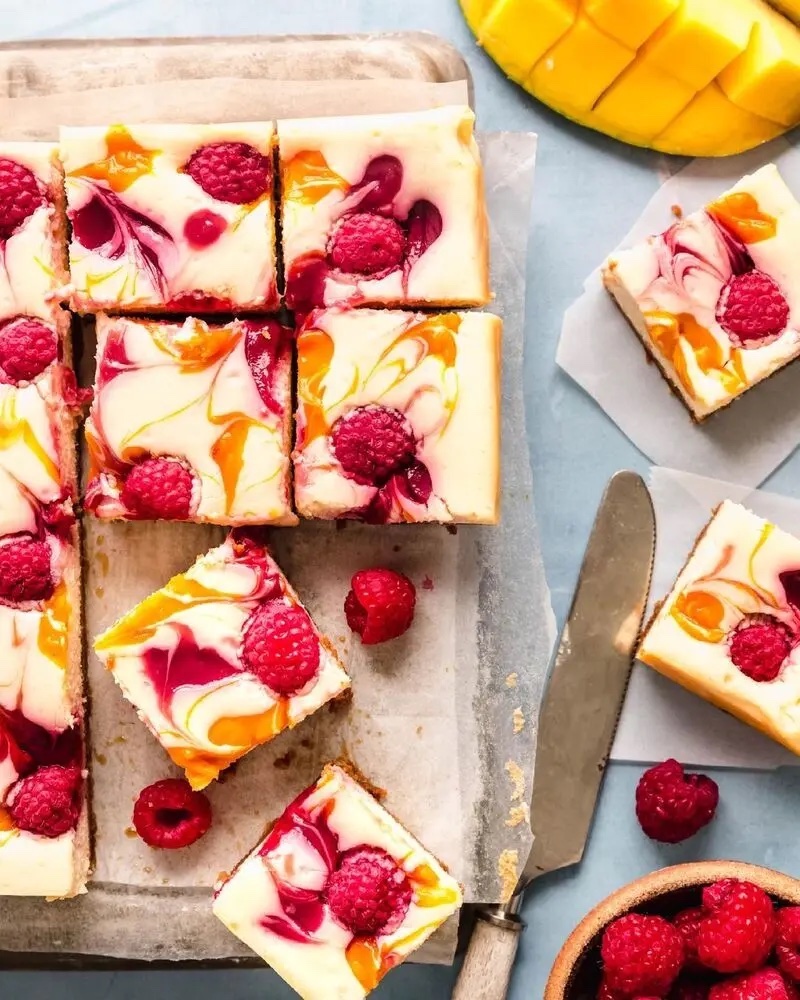 Raspberry mango cheesecake bars with graham cracker crust.