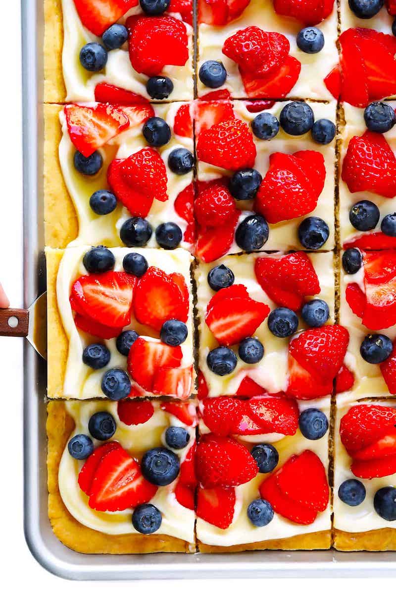 Summer fruit pizza with fresh berries and cream cheese frosting on a cookie crust.