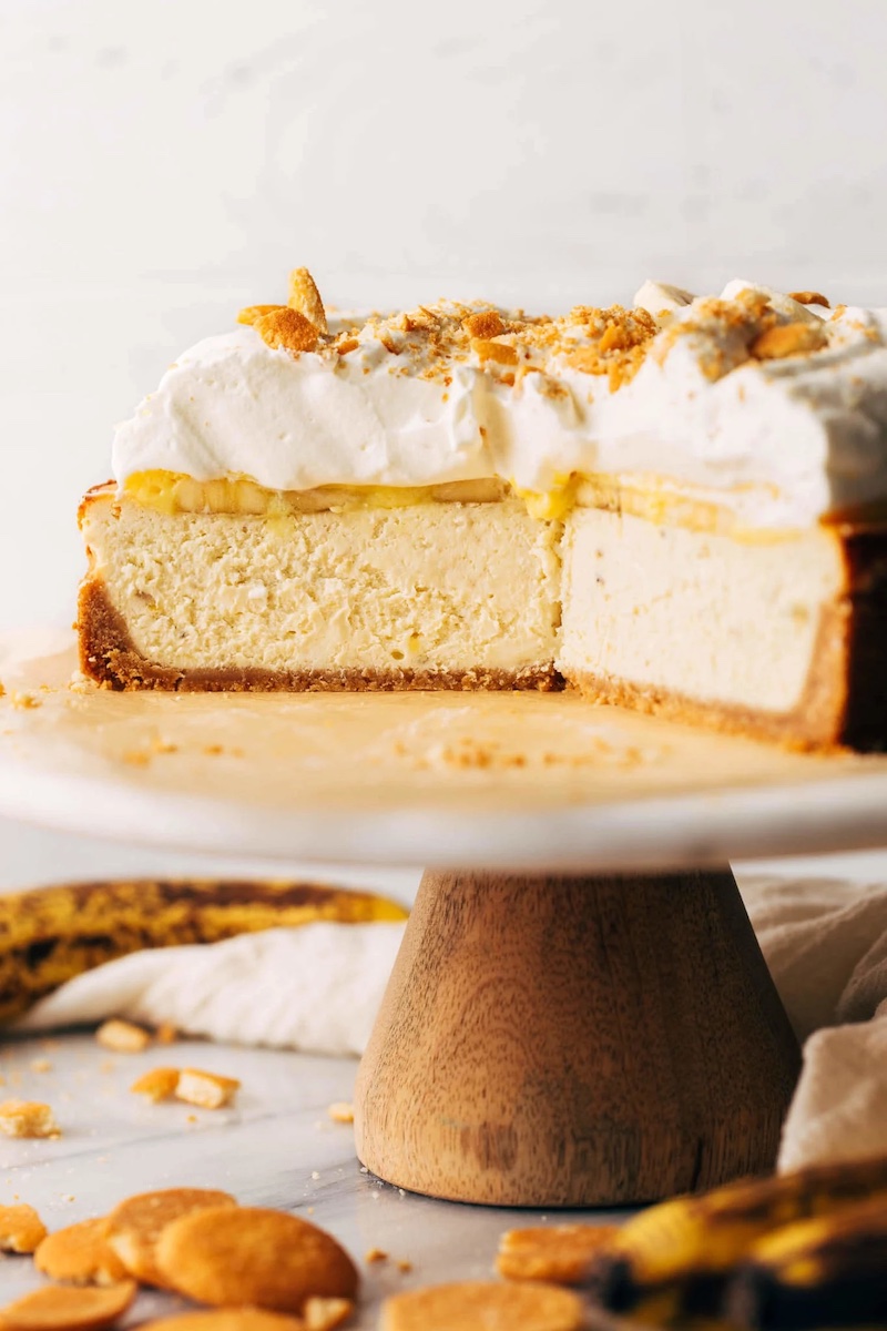 Banana pudding cheesecake with fluffy whipped cream and crushed vanilla wafers on top.