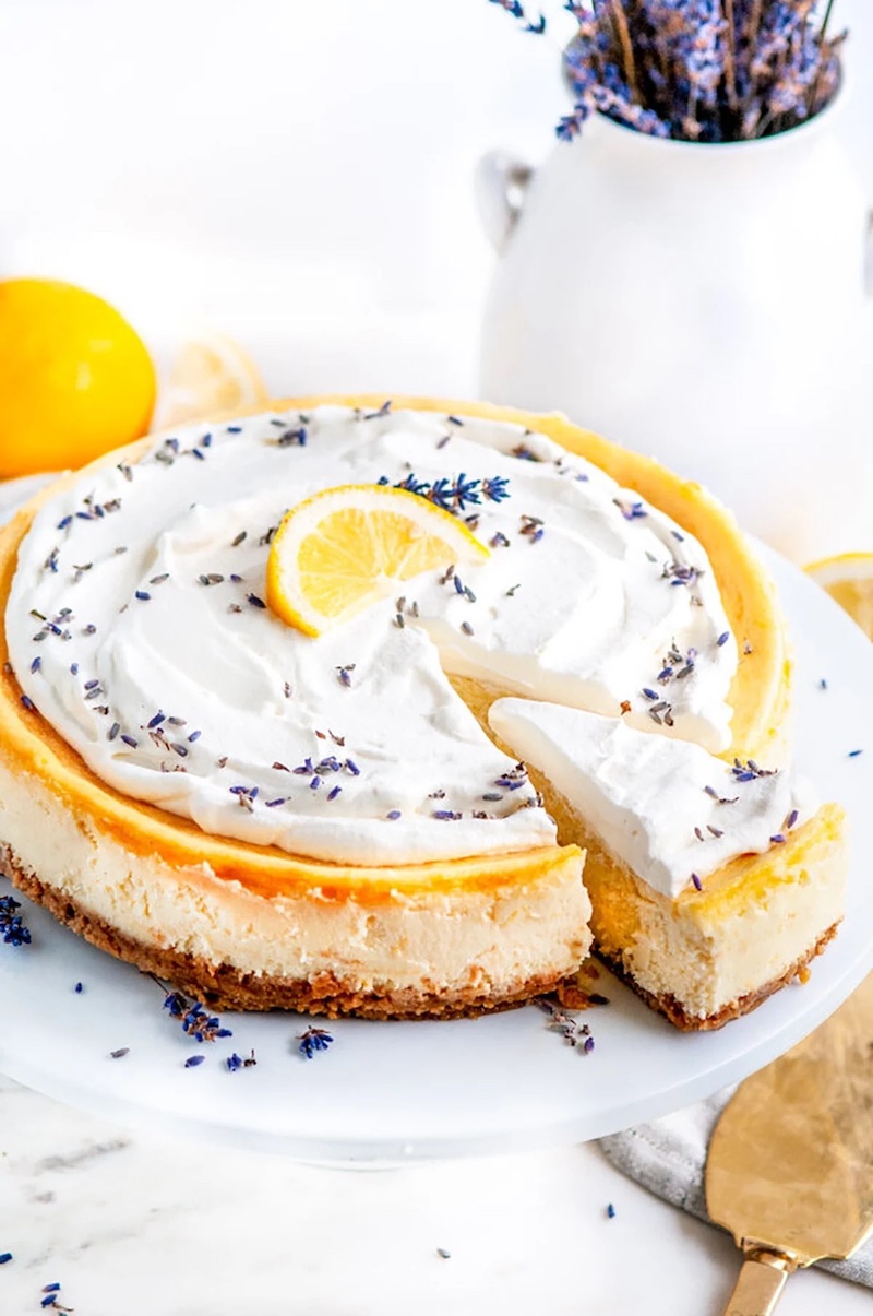 Lemon lavender mascarpone cheesecake with whipped cream and lavender flowers on top.