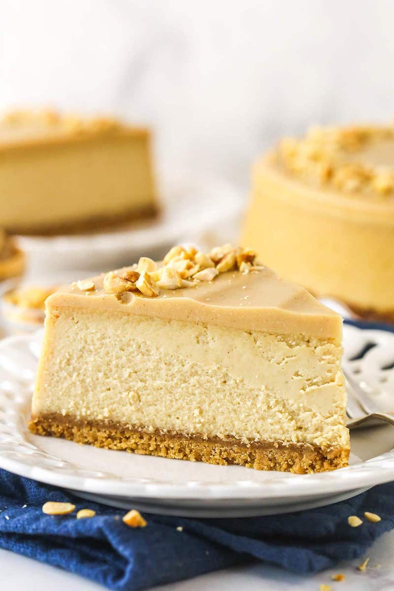 Slice of peanut butter cheesecake with a Nutter Butter crust topped with a thick peanut butter ganache.