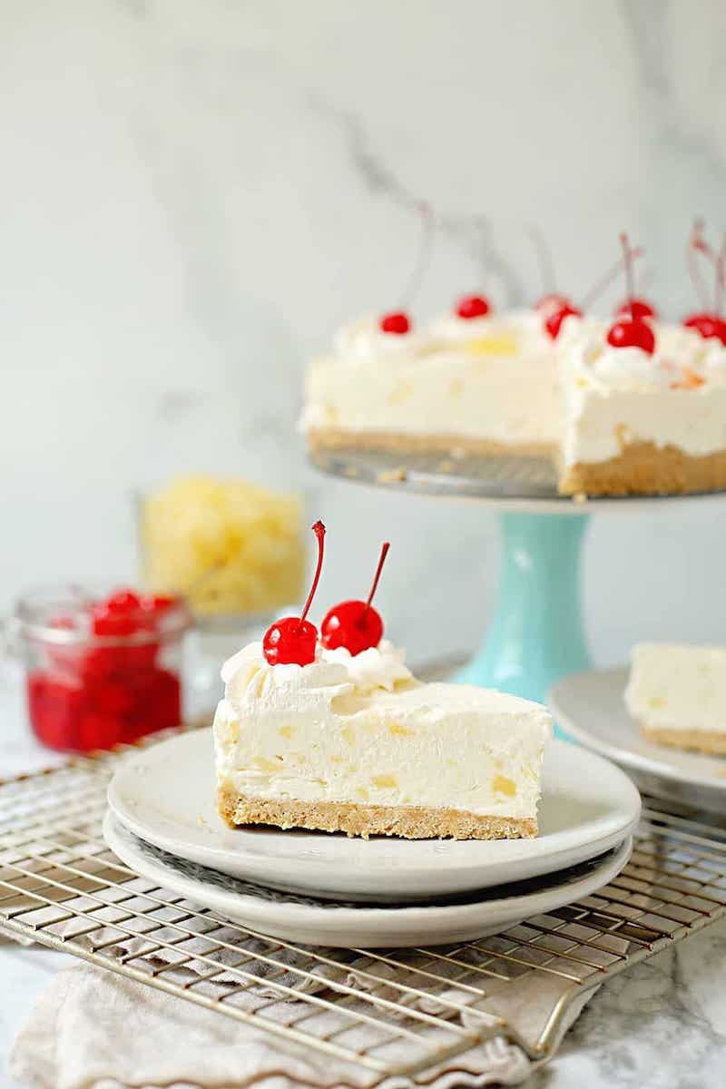Pina colada no bake cheesecake with coconut cream, pineapple, and whipped cream topped with maraschino cherries.